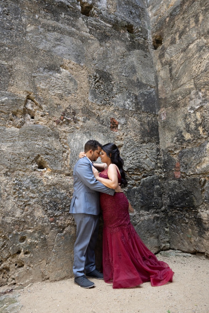 Abrazo íntimo contra el muro de piedra