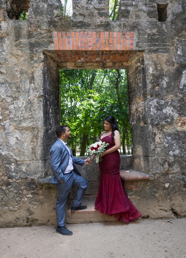 Carlos arrodillado en el arco de piedra colonial